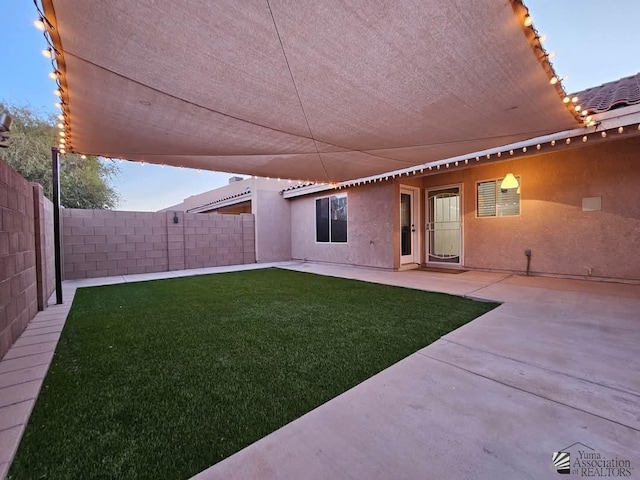 exterior space featuring a fenced backyard, a tile roof, a lawn, stucco siding, and a patio area