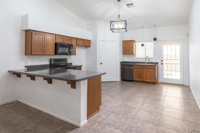 kitchen featuring pendant lighting, brown cabinets, visible vents, and black appliances