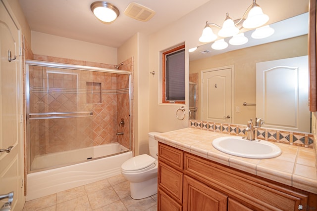 full bathroom featuring toilet, tile patterned floors, vanity, and shower / bath combination with glass door