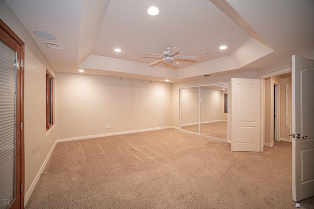 basement featuring light carpet and ceiling fan