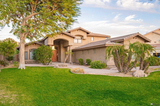 mediterranean / spanish house featuring a front lawn