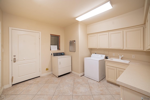 clothes washing area with cabinets, washing machine and dryer, sink, and light tile patterned floors