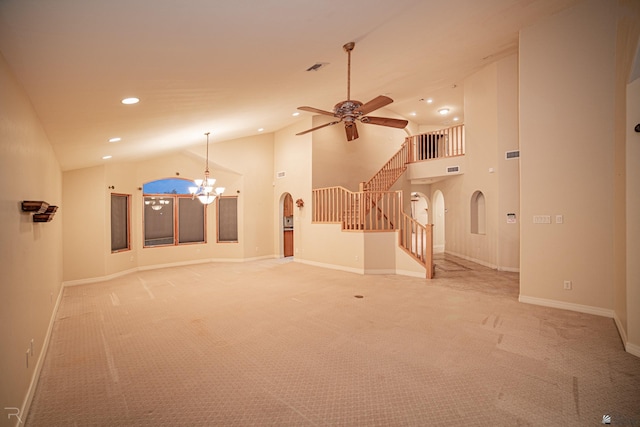 unfurnished living room featuring ceiling fan with notable chandelier, high vaulted ceiling, and carpet