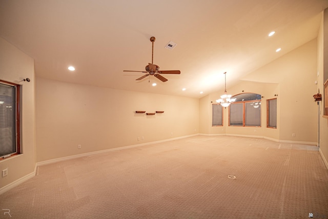 unfurnished living room featuring vaulted ceiling, ceiling fan with notable chandelier, and light carpet