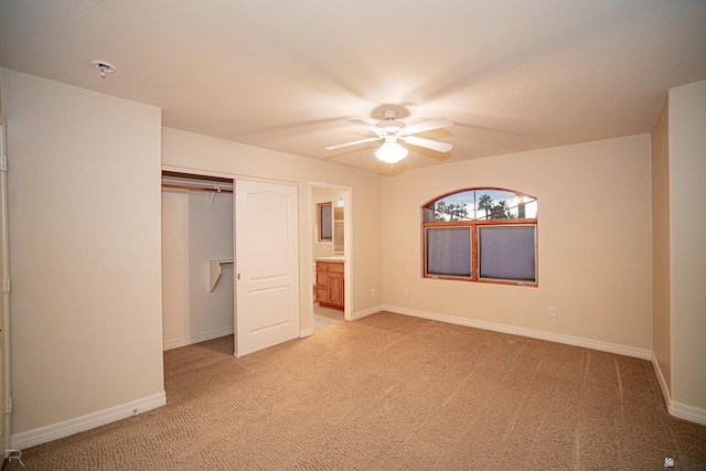 unfurnished bedroom featuring ensuite bathroom, a closet, ceiling fan, and carpet