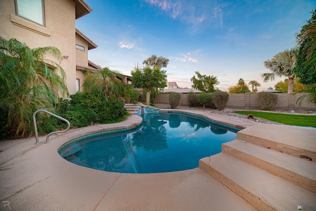 pool at dusk with a patio area