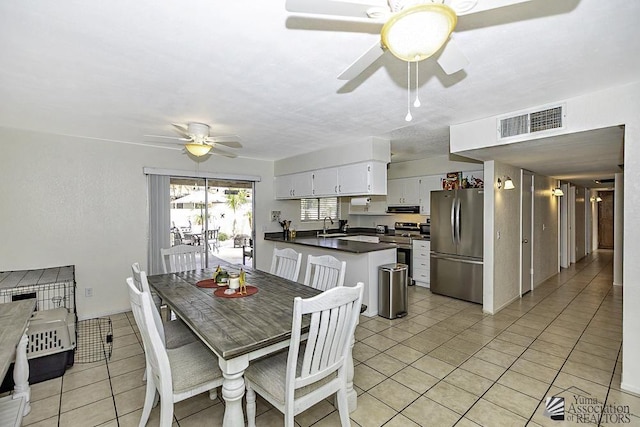 dining area featuring sink, ceiling fan, and light tile patterned floors