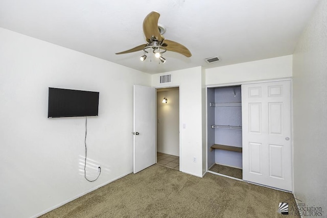 unfurnished bedroom with a closet, ceiling fan, and carpet floors