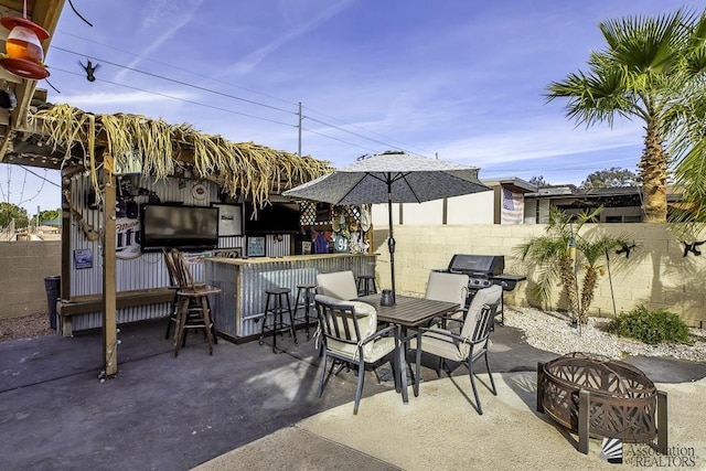 view of patio / terrace with an outdoor fire pit, grilling area, and exterior bar