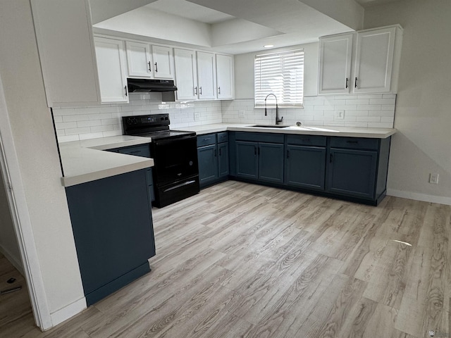 kitchen featuring light wood-type flooring, a sink, under cabinet range hood, black range with electric cooktop, and white cabinetry