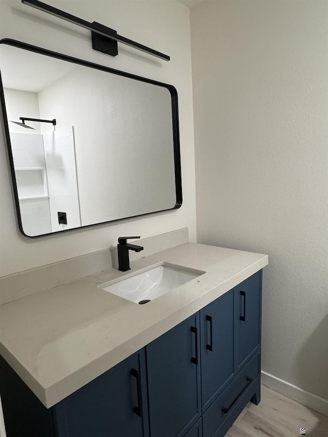 bathroom featuring baseboards, wood finished floors, and vanity