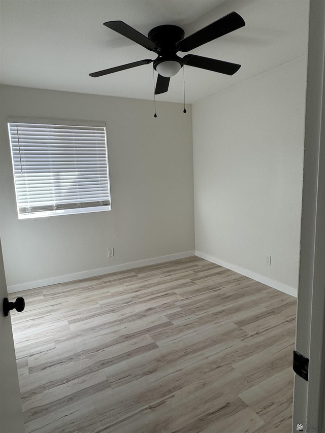 unfurnished room featuring baseboards and wood finished floors