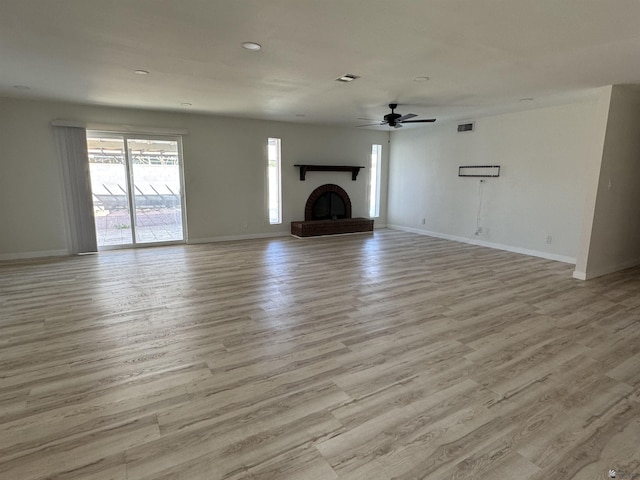 unfurnished living room with baseboards, wood finished floors, and a fireplace