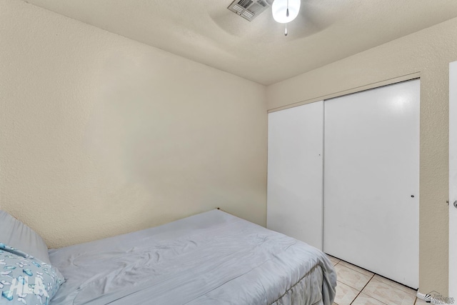 tiled bedroom featuring a closet and ceiling fan