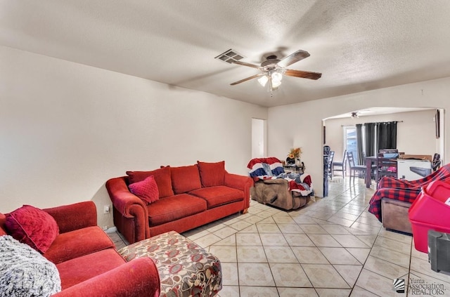 living room with light tile patterned floors, a textured ceiling, and ceiling fan