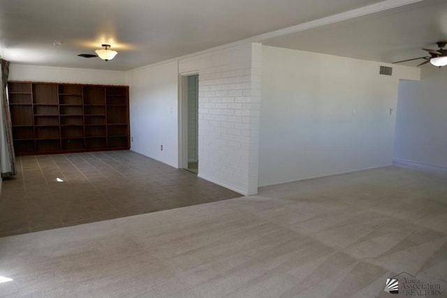 tiled empty room featuring visible vents, a ceiling fan, and carpet floors