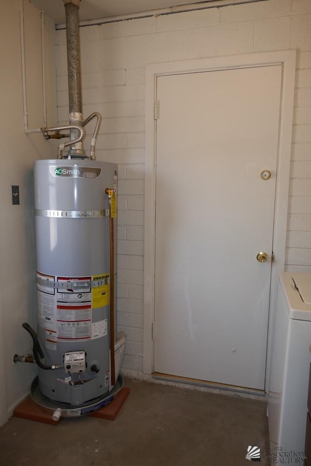 utility room featuring water heater and washer / dryer