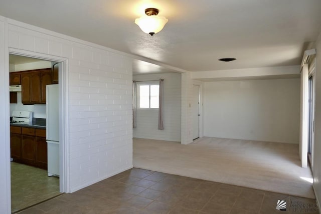 tiled spare room with carpet floors