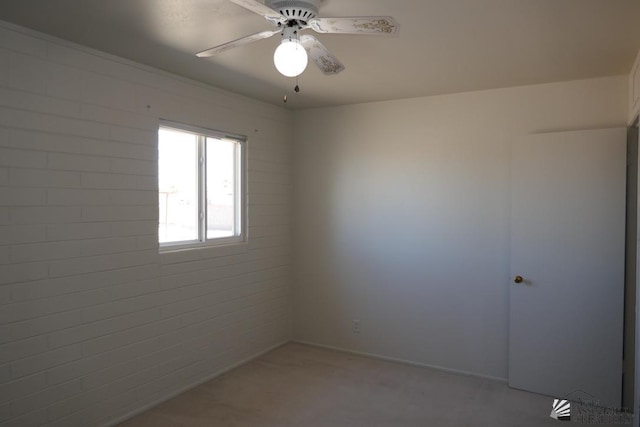 spare room with light carpet and a ceiling fan