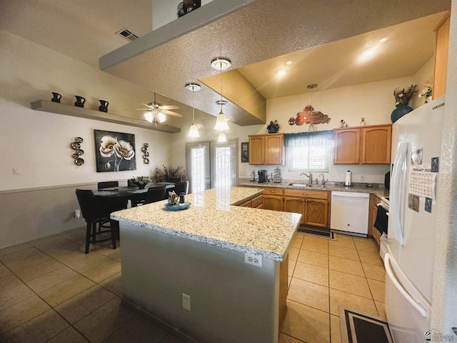 kitchen with visible vents, light tile patterned floors, a sink, white appliances, and hanging light fixtures