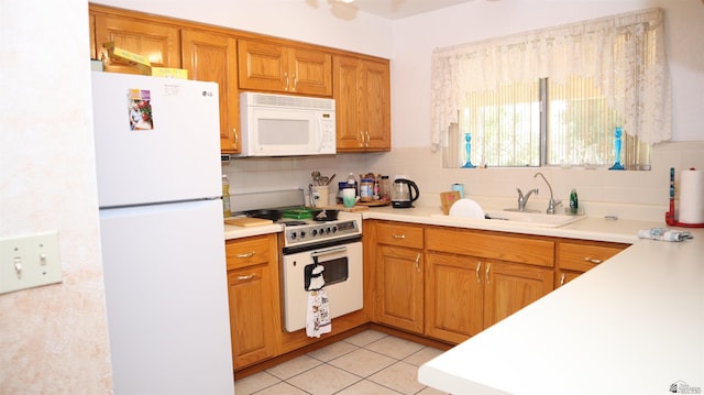 kitchen featuring decorative backsplash, sink, light tile patterned floors, and white appliances