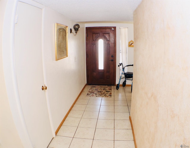 foyer featuring light tile patterned floors and a textured ceiling