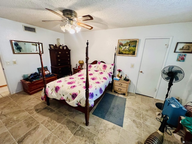 bedroom featuring ceiling fan and a textured ceiling