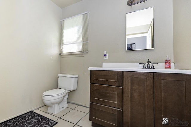 half bath with toilet, tile patterned flooring, and vanity