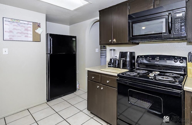 kitchen featuring light tile patterned floors, black appliances, dark brown cabinets, and light countertops