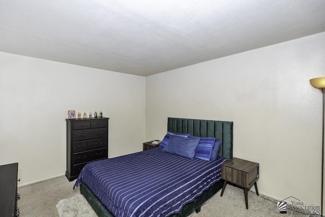 bedroom featuring light carpet and baseboards