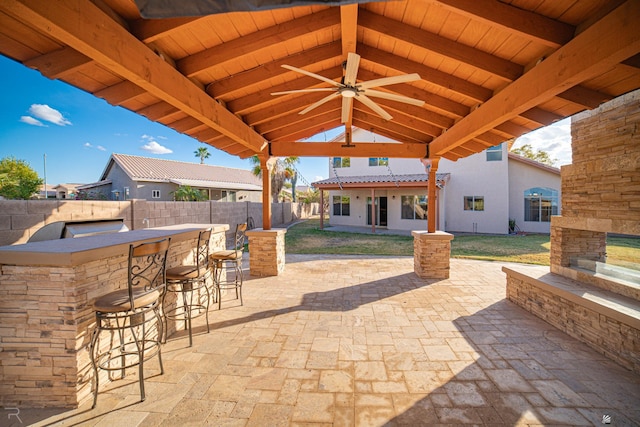 view of patio featuring a gazebo, ceiling fan, and exterior bar