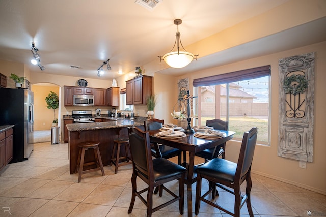 tiled dining room featuring rail lighting