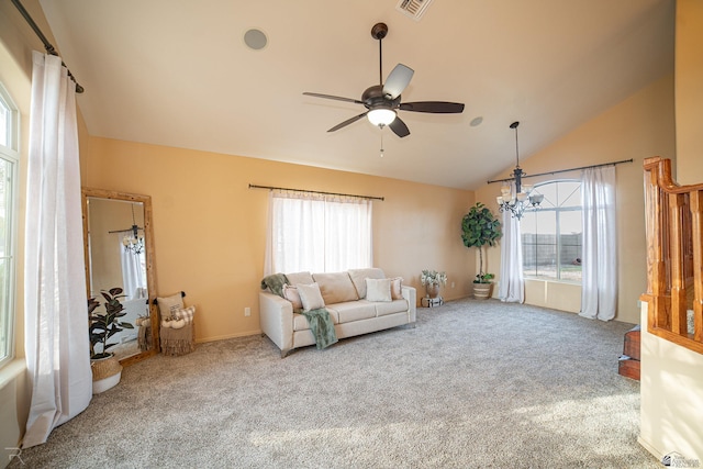 unfurnished living room featuring ceiling fan with notable chandelier, vaulted ceiling, and carpet flooring