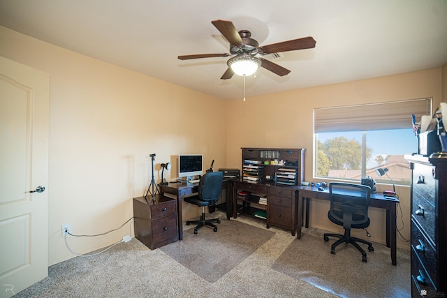 carpeted office space featuring ceiling fan