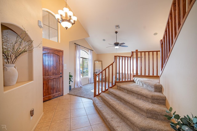 entrance foyer featuring lofted ceiling, light tile patterned floors, and ceiling fan with notable chandelier