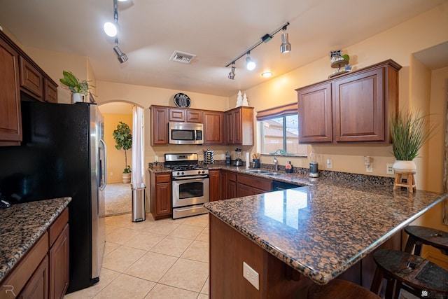 kitchen featuring stainless steel appliances, a breakfast bar, sink, and kitchen peninsula