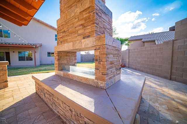 view of patio / terrace featuring an outdoor stone fireplace