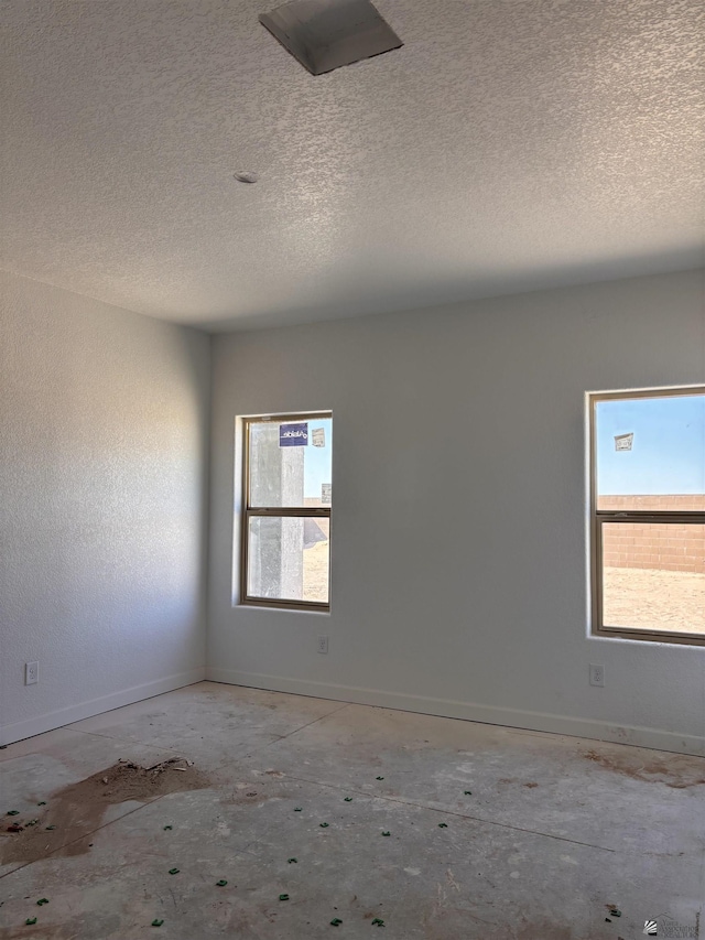 unfurnished room with a healthy amount of sunlight and a textured ceiling