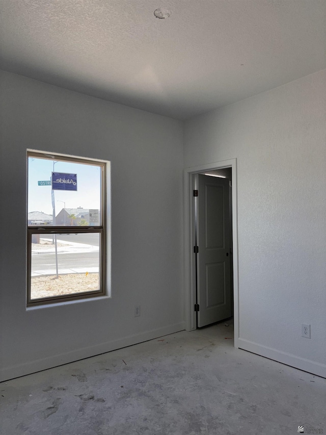 unfurnished room featuring a textured ceiling