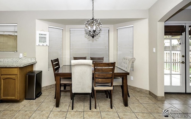 dining room with light tile patterned floors, baseboards, and an inviting chandelier