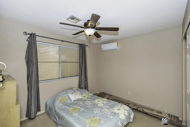 bedroom with ceiling fan, a textured ceiling, a wall unit AC, carpet floors, and visible vents