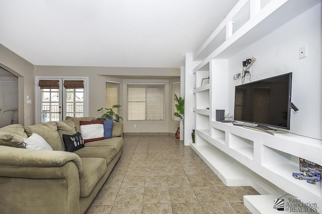 living room featuring light tile patterned flooring and built in features