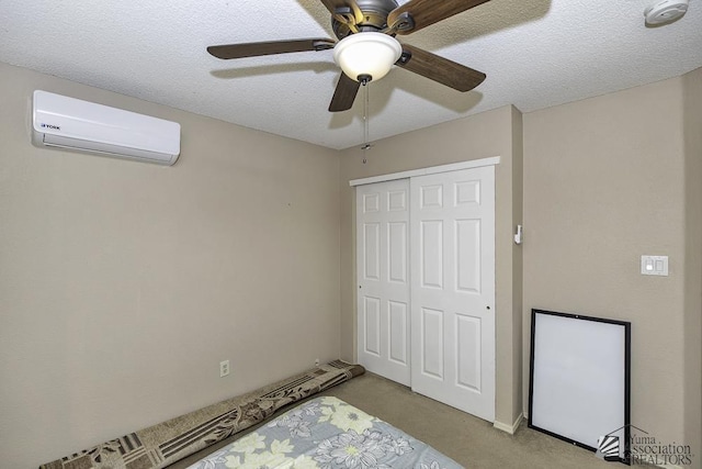 unfurnished bedroom featuring carpet, a closet, a wall unit AC, and a textured ceiling