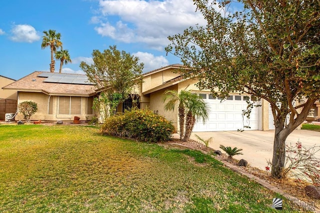 view of front of house featuring driveway, an attached garage, roof mounted solar panels, a front lawn, and stucco siding