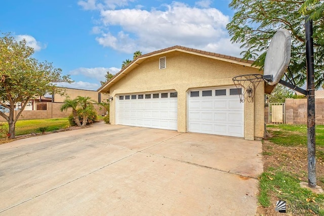 view of front facade featuring a garage, fence, and stucco siding