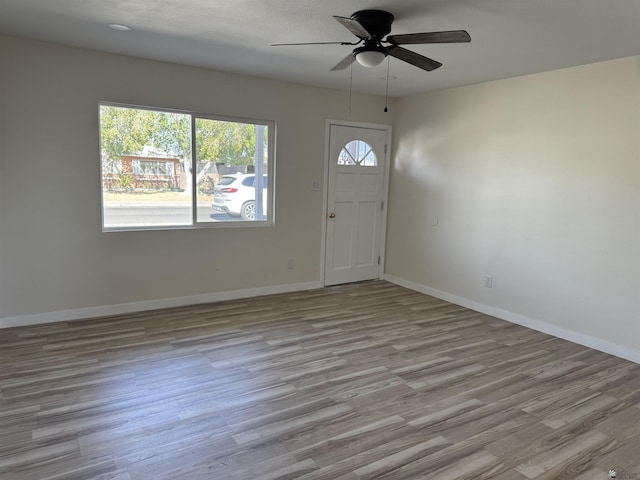 foyer entrance with ceiling fan and light wood-type flooring