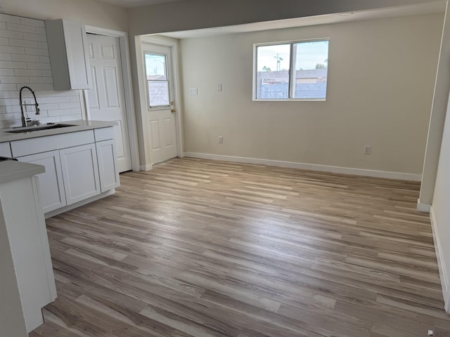 interior space featuring sink, a wealth of natural light, and light wood-type flooring