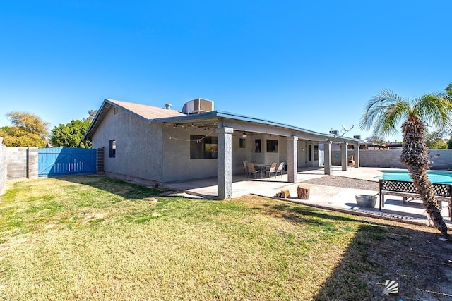 rear view of house with a patio area, a fenced backyard, a yard, and stucco siding