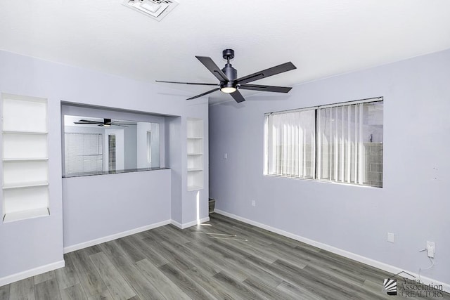 unfurnished room featuring ceiling fan, wood finished floors, visible vents, and baseboards