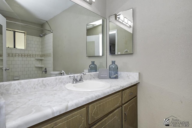 bathroom featuring toilet, walk in shower, and vanity